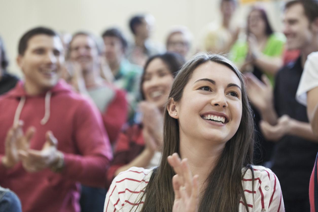 Attendees at a conference applauding the speaker